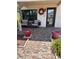 Inviting front porch with tiled flooring, two comfy chairs, and attractive landscaping at 9920 Eagles Point Cir # 2, Port Richey, FL 34668