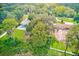 Aerial view of a property with a pool, trampoline, and surrounding trees at 21415 Hopson Rd, Land O Lakes, FL 34638