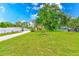 Large, grassy front yard with a concrete driveway at 21415 Hopson Rd, Land O Lakes, FL 34638