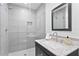 Modern bathroom with a walk-in shower and granite vanity at 8716 Elmwood Ln, Tampa, FL 33615