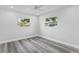Spacious bedroom featuring wood-look floors and two windows at 8716 Elmwood Ln, Tampa, FL 33615