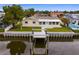 Waterfront home featuring a private dock, well-kept lawn, and bright exterior paint at 8716 Elmwood Ln, Tampa, FL 33615