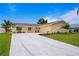 Newly renovated single-story home with a two-car garage and landscaped yard at 8716 Elmwood Ln, Tampa, FL 33615