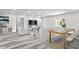 Open concept living and dining area with grey wood-look flooring at 8716 Elmwood Ln, Tampa, FL 33615