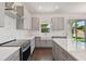 Modern kitchen with gray cabinets, white quartz countertops, and stainless steel appliances at 210 E Janette Ave, Tampa, FL 33603
