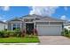 Charming one-story home with stone accents, gray siding, and a well-manicured lawn at 18142 Beach Ranch Ter, Lakewood Ranch, FL 34211