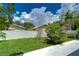 Backyard with grassy area, garden, and white fence at 3203 W San Luis St, Tampa, FL 33629