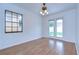Bright bedroom with wood floors, white walls, ceiling fan, and glass paneled doors to the outside at 3203 W San Luis St, Tampa, FL 33629