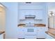 Bright kitchen features white cabinets and range hood over a white stove and butcher block countertops at 3203 W San Luis St, Tampa, FL 33629