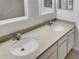 Double vanity bathroom with neutral countertops and white cabinets at 227 Mystic Falls Dr, Apollo Beach, FL 33572