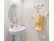 Small bathroom with pedestal sink and round mirror at 8491 Essington St, New Port Richey, FL 34654