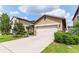 Tan two-car garage house with landscaping at 1515 Gadsden Point Pl, Ruskin, FL 33570