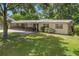 Ranch-style home with carport, mature trees, and spacious lawn at 1213 E Frierson Ave, Tampa, FL 33603