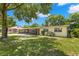 Ranch-style home with a spacious lawn and covered patio at 1213 E Frierson Ave, Tampa, FL 33603