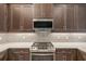 Stainless steel range and microwave hood above cabinets in modern kitchen at 4838 Sevilla Shores Dr, Wimauma, FL 33598