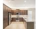 Modern kitchen with dark brown cabinets, stainless steel appliances, and quartz countertops at 4838 Sevilla Shores Dr, Wimauma, FL 33598