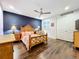 Comfortable bedroom with a dark blue accent wall and wood flooring at 13506 Messina Loop # 105, Bradenton, FL 34211