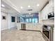 Open kitchen boasts white cabinets, stainless steel appliances, and breakfast bar at 13506 Messina Loop # 105, Bradenton, FL 34211