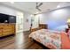Cozy bedroom with wood flooring, ensuite bathroom access, and a ceiling fan at 13506 Messina Loop # 105, Bradenton, FL 34211