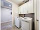Bright laundry room with washer, dryer, and storage at 13506 Messina Loop # 105, Bradenton, FL 34211