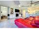 Open living room showcasing a red sectional sofa, built-in shelving, and fireplace at 13506 Messina Loop # 105, Bradenton, FL 34211