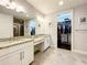 Double vanity bathroom with granite countertops and access to a walk-in closet at 13506 Messina Loop # 105, Bradenton, FL 34211