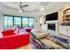 Living area with red sectional sofa, fireplace, and large sliding doors at 13506 Messina Loop # 105, Bradenton, FL 34211