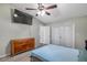 Well-lit bedroom with a large TV, dresser, and access to a hallway at 7127 Otter Creek Dr, New Port Richey, FL 34655