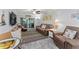 Comfortable living room featuring brown leather sofas, a large TV, and access to a balcony at 10301 Gulf Blvd # 201, Treasure Island, FL 33706