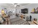 Spacious living room showcasing a brown leather couch, large TV, and patterned rug at 10301 Gulf Blvd # 201, Treasure Island, FL 33706