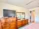 Bedroom featuring dark wood dresser, a television, and a doorway leading to another room at 306 Friar Ct # B, Sun City Center, FL 33573