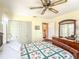Bright bedroom features a ceiling fan, neutral walls, and a quaint patchwork quilt at 306 Friar Ct # B, Sun City Center, FL 33573