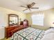 Bedroom featuring a bed with patterned quilt, dresser, window, and ceiling fan at 306 Friar Ct # B, Sun City Center, FL 33573