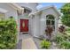 Inviting house entrance with a red door, landscaping, and walkway at 4124 Beaumont Loop, Spring Hill, FL 34609