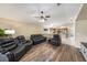 Relaxing living room with black leather reclining sofas, hardwood floors and ceiling fan at 4124 Beaumont Loop, Spring Hill, FL 34609