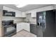 Modern kitchen featuring white cabinets and black appliances at 16203 Lakehead Ct, Tampa, FL 33618