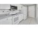 White kitchen with stainless steel appliances and tile floor at 2206 Mayfield Palms Ln # 69, Sun City Center, FL 33573