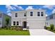Two-story home with neutral-colored stucco, a two-car garage, well-maintained landscaping and a paver walkway to the front door at 16013 7Th E Ave, Bradenton, FL 34212