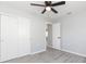 Bedroom with ceiling fan, wood-look floors, and sliding door closet at 8136 Hixton Dr, Port Richey, FL 34668