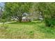 Brick house partially obscured by trees and overgrown grass at 10912 672 Hwy, Riverview, FL 33579