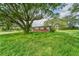 Brick house with overgrown grass and large tree at 10912 672 Hwy, Riverview, FL 33579