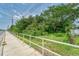 Vacant lot with sidewalk, railing, and dense vegetation at 10912 672 Hwy, Riverview, FL 33579