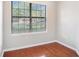 Cozy bedroom with wood floors and large window at 2220 Chianti Pl # 8-0812, Palm Harbor, FL 34683
