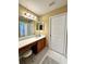 Well-lit bathroom featuring vanity with seating area, a large mirror, and ceramic tile floors at 12384 Creek Edge Dr, Riverview, FL 33579