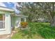 Well-maintained backyard featuring lush green grass, mature trees, and verdant landscaping providing shade and a tranquil setting at 2309 Mooney. Pl, Sun City Center, FL 33573