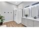 Modern bathroom featuring a glass walk-in shower, dual sinks, and wood-look flooring at 2309 Mooney. Pl, Sun City Center, FL 33573