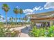 Community pool area with ample seating, umbrellas, lush landscaping, and covered patio at 2309 Mooney. Pl, Sun City Center, FL 33573