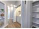 Hallway with laundry closet, open shelving, and access to the rooms at 2309 Mooney. Pl, Sun City Center, FL 33573