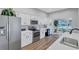 Modern kitchen with stainless steel appliances, white cabinets, and wood flooring at 2309 Mooney. Pl, Sun City Center, FL 33573