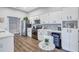Modern kitchen with stainless steel appliances, white cabinets, wood floors, and dining area at 2309 Mooney. Pl, Sun City Center, FL 33573